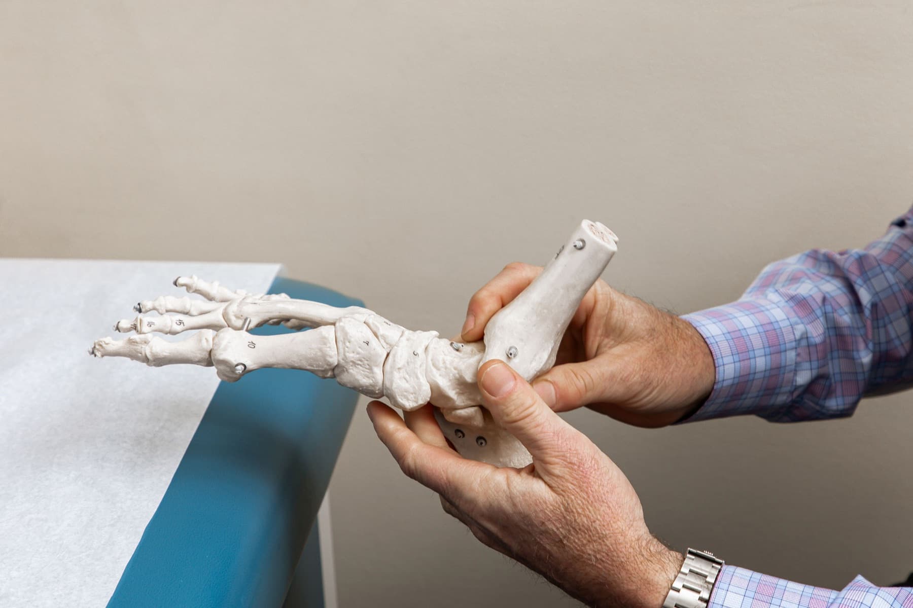 Dr. Feldman holding a foot-and-ankle anatomical model to explain the bones